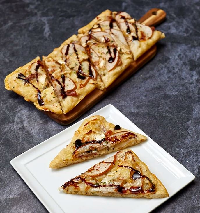 Pizza artisanale aux poires et au prosciutto avec un glaçage balsamique